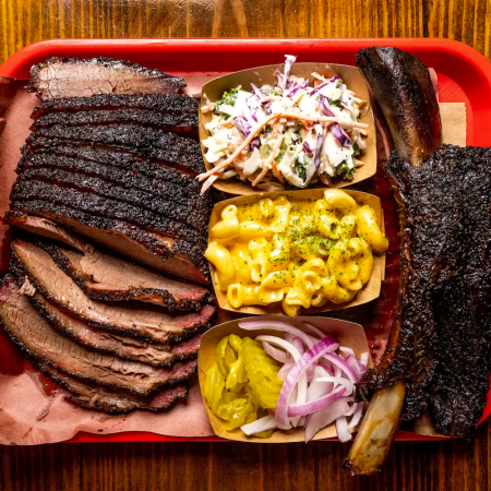 BBQ on a plate, including meat, picked sides, coleslaw and mac and cheese, from Terry Black's, one of the best BBQ joints in Austin, Texas