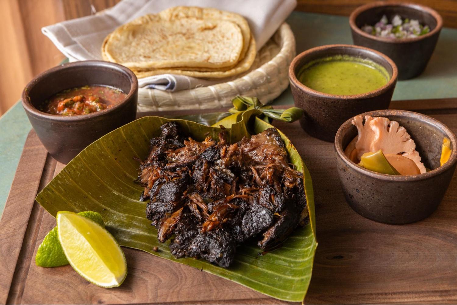 Spread of meat, sauce and tortillas on a table