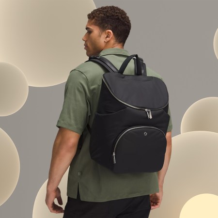 A man wearing the Lululemon New Parent Backpack, a stylish diaper bag that we tested and reviewed