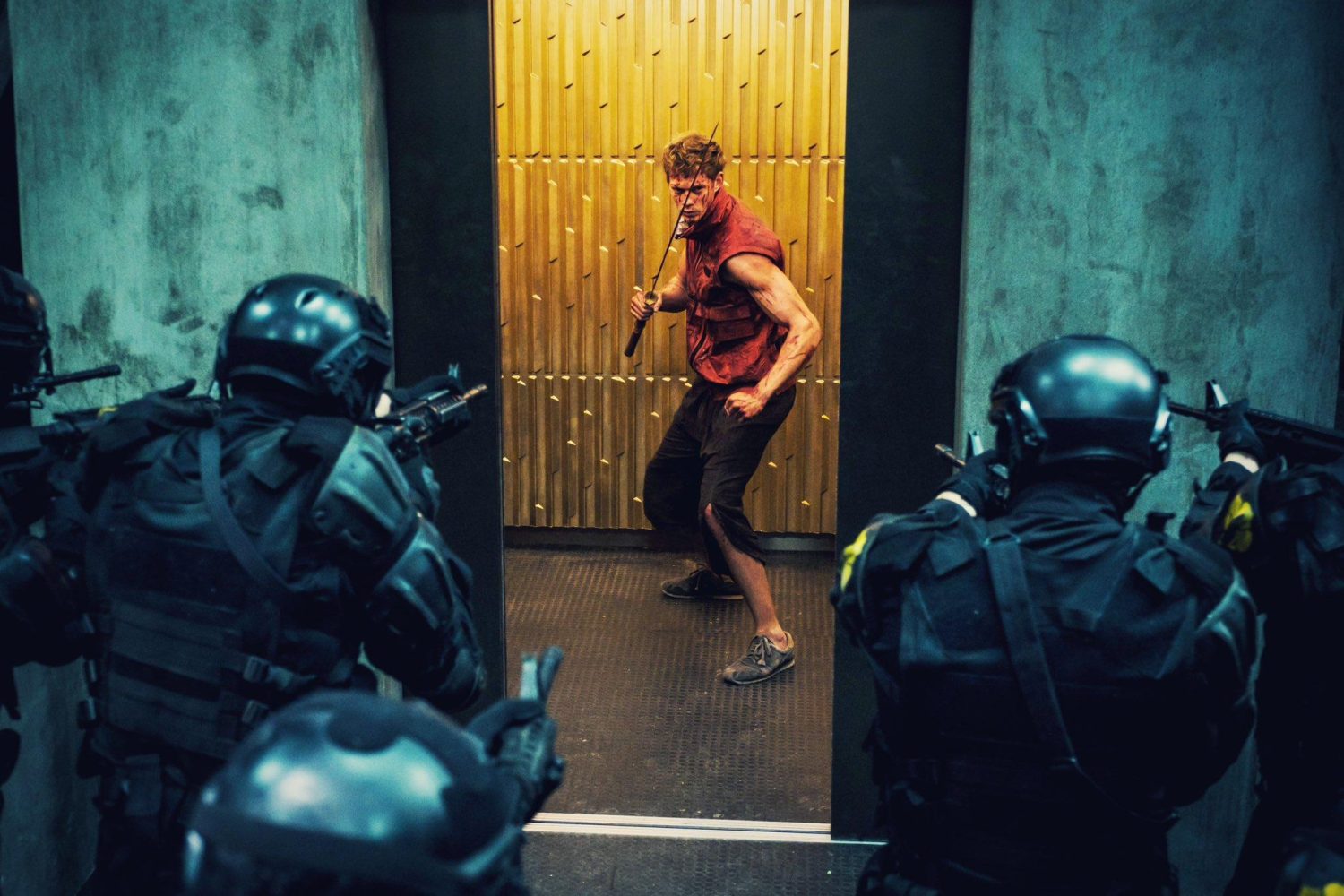 actor in red top black pants fighting people in all black and headgear