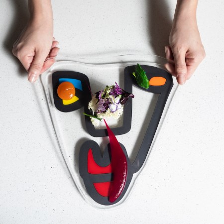 Food being handed out on a platter with flowers in the middle