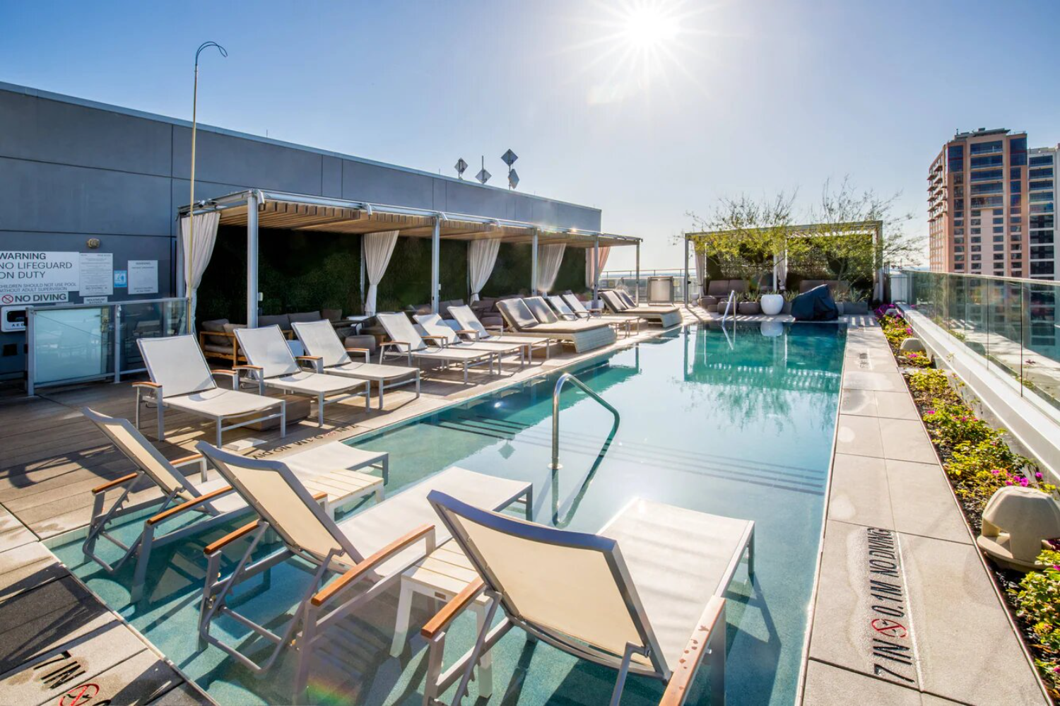 rooftop pool on a sunny day, empty chairs