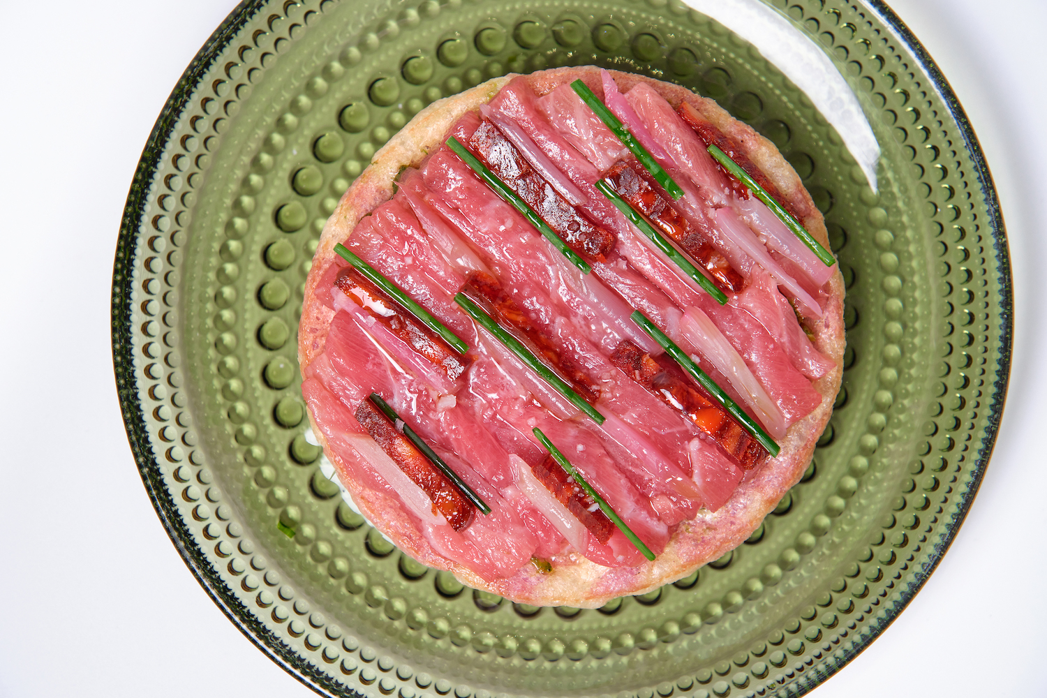 Spanish bluefin tuna with chorizo on a green plate from Little Mad