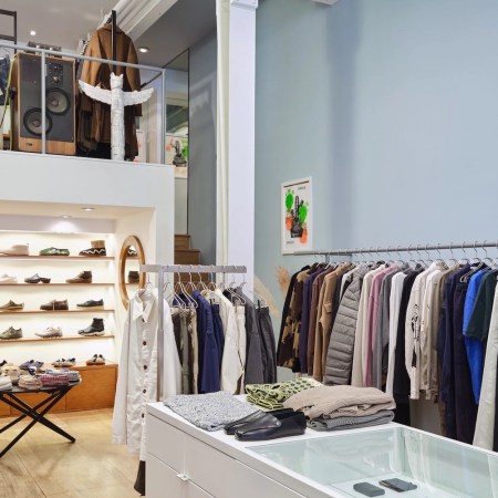 Inside of Mohawk Man with clothes hanging on racks and on display in tables and on shelves