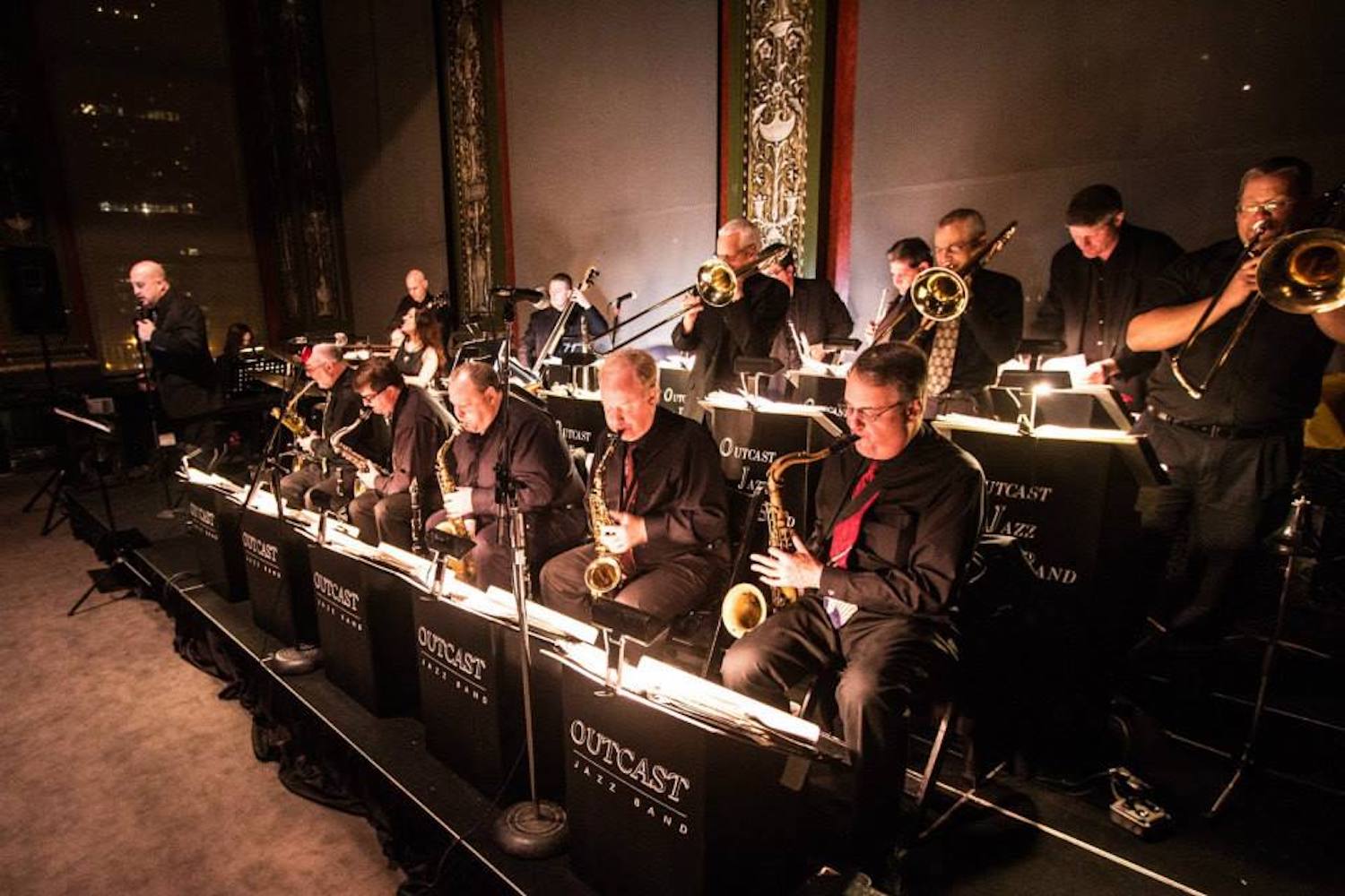 People in a band performing on stage with sheet music