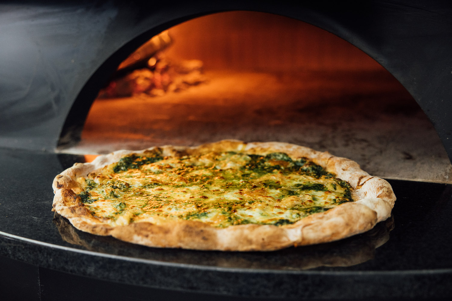Pizza in front of a brick oven