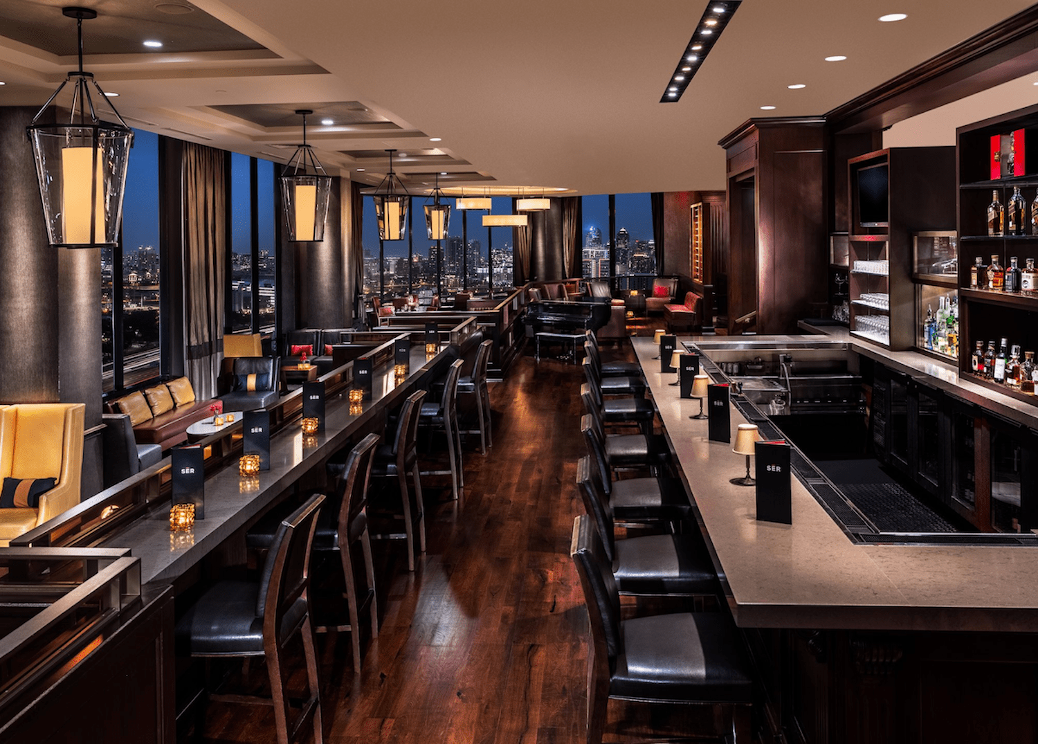 Interior of SER Steaks, with floor-to-ceiling windows and dark brown wooden and black finishes