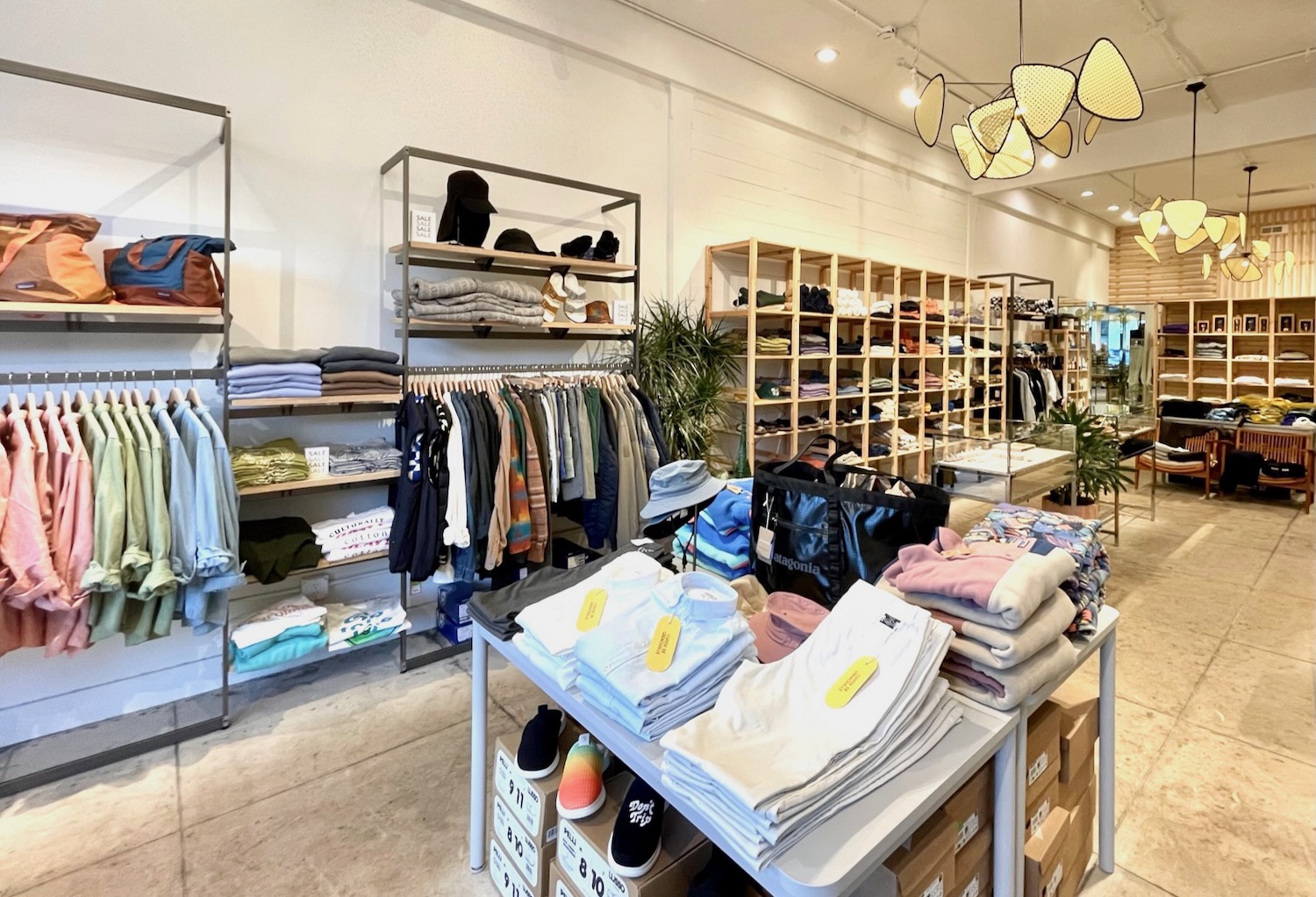 Inside of the Wittmore with clothes folded on tables and shelves and hanging on racks