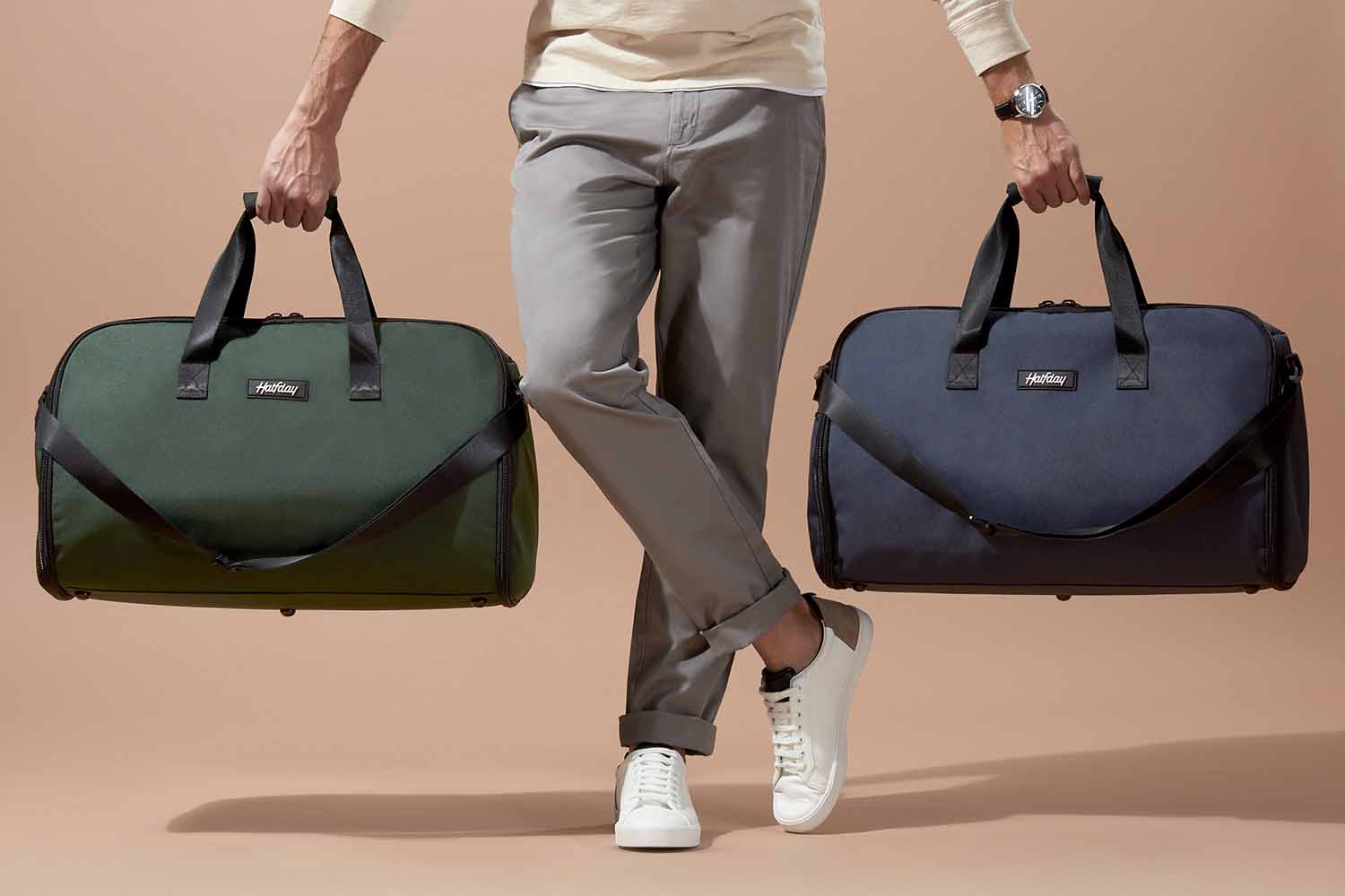 A person from the waist down holding two examples of the Garment Duffel by Halfday