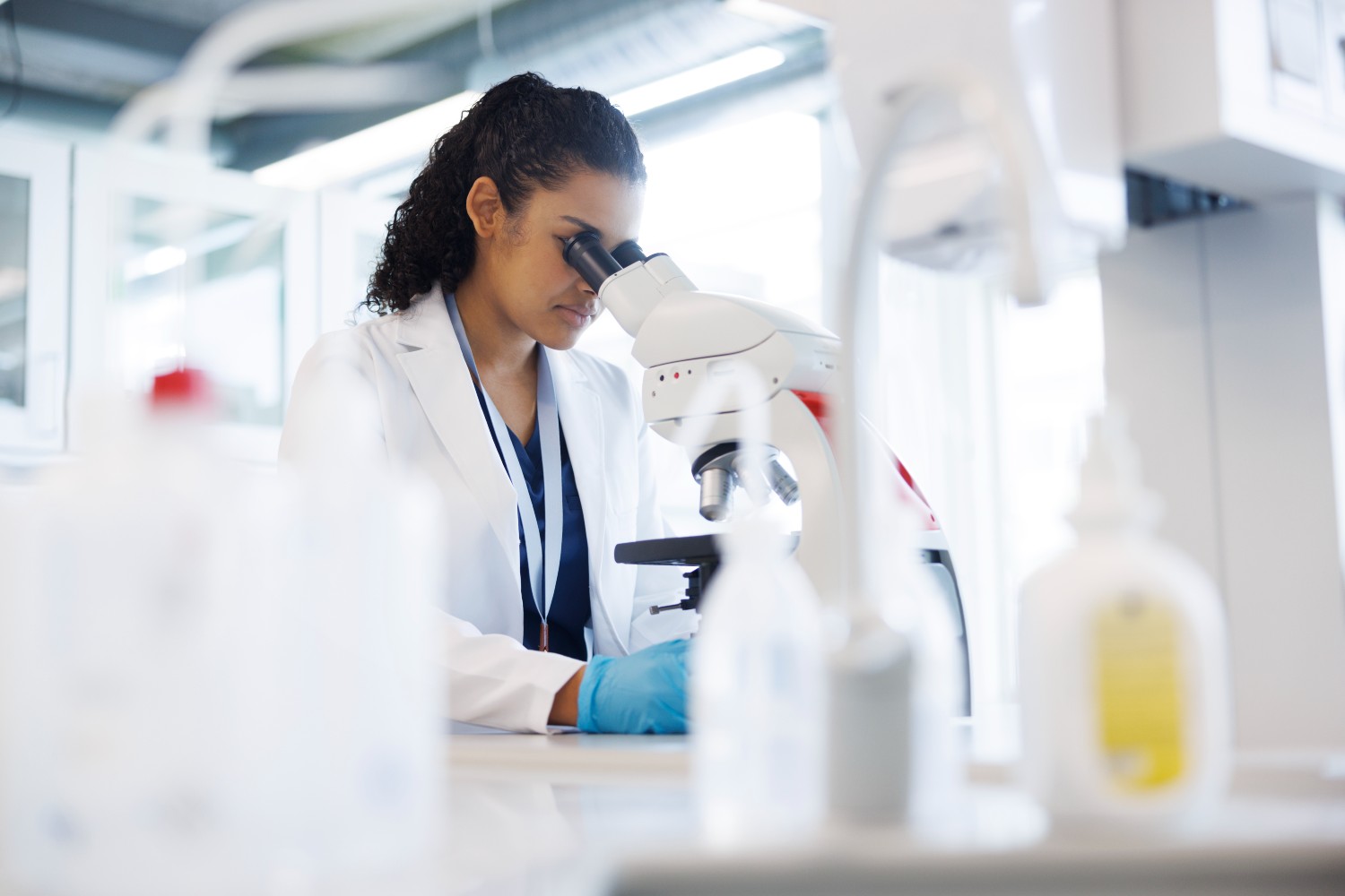 Scientist in lab looking into a microscope