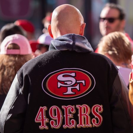 The logo of the San Francisco 49ers on the back of a fan's jacket.