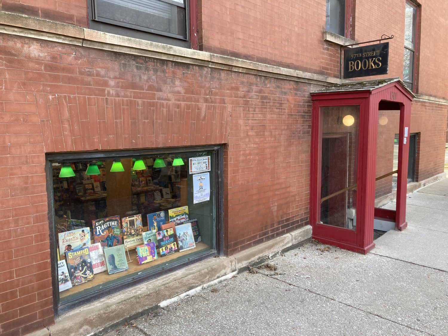 outside of store, brick wall, sign, and red entrance