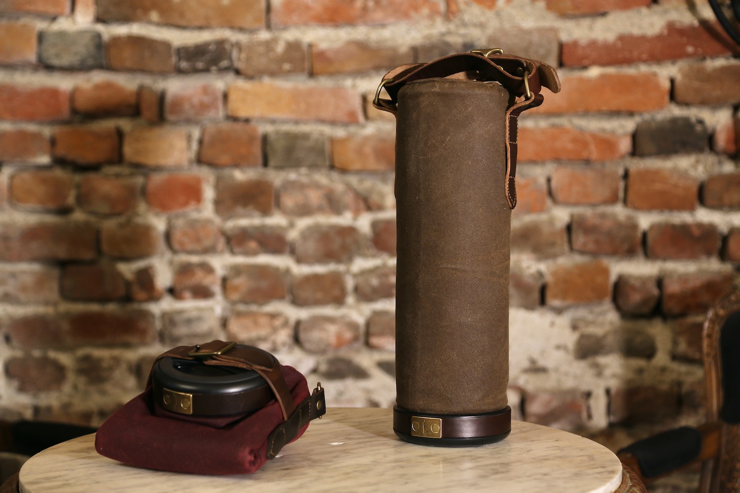 two vinarmour wine carriers side by side in front of a brick wall, one collapsed and one open