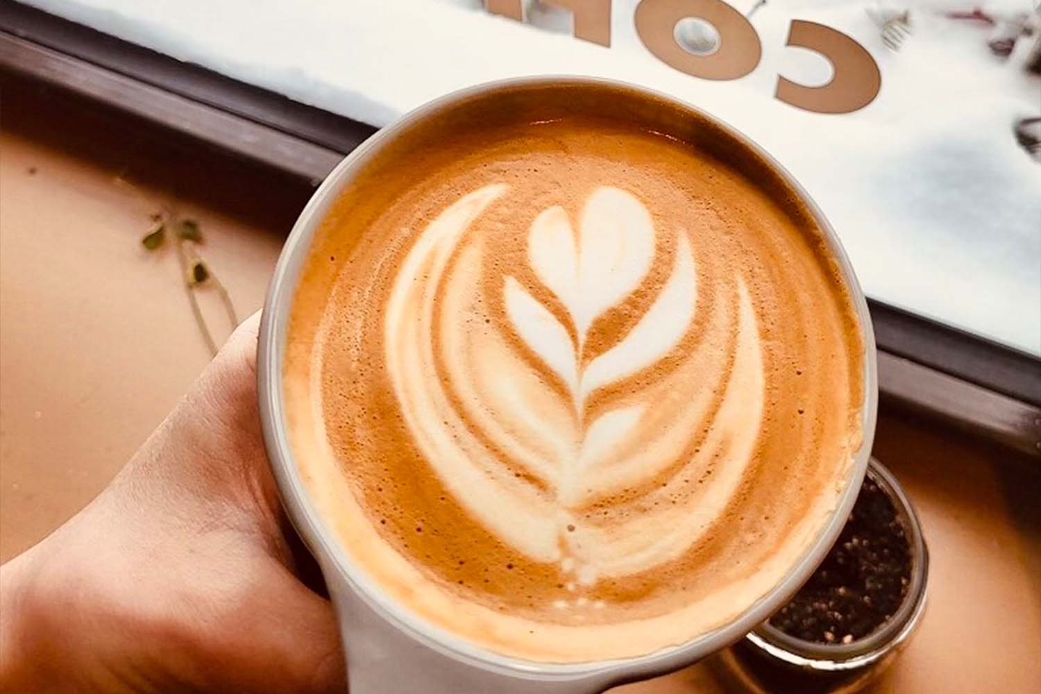 a latte in a ceramic mug with heart shaped art