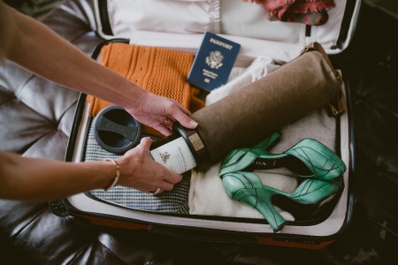 the vinarmour wine carrier in a suitcase with an american passport and green prada shoes