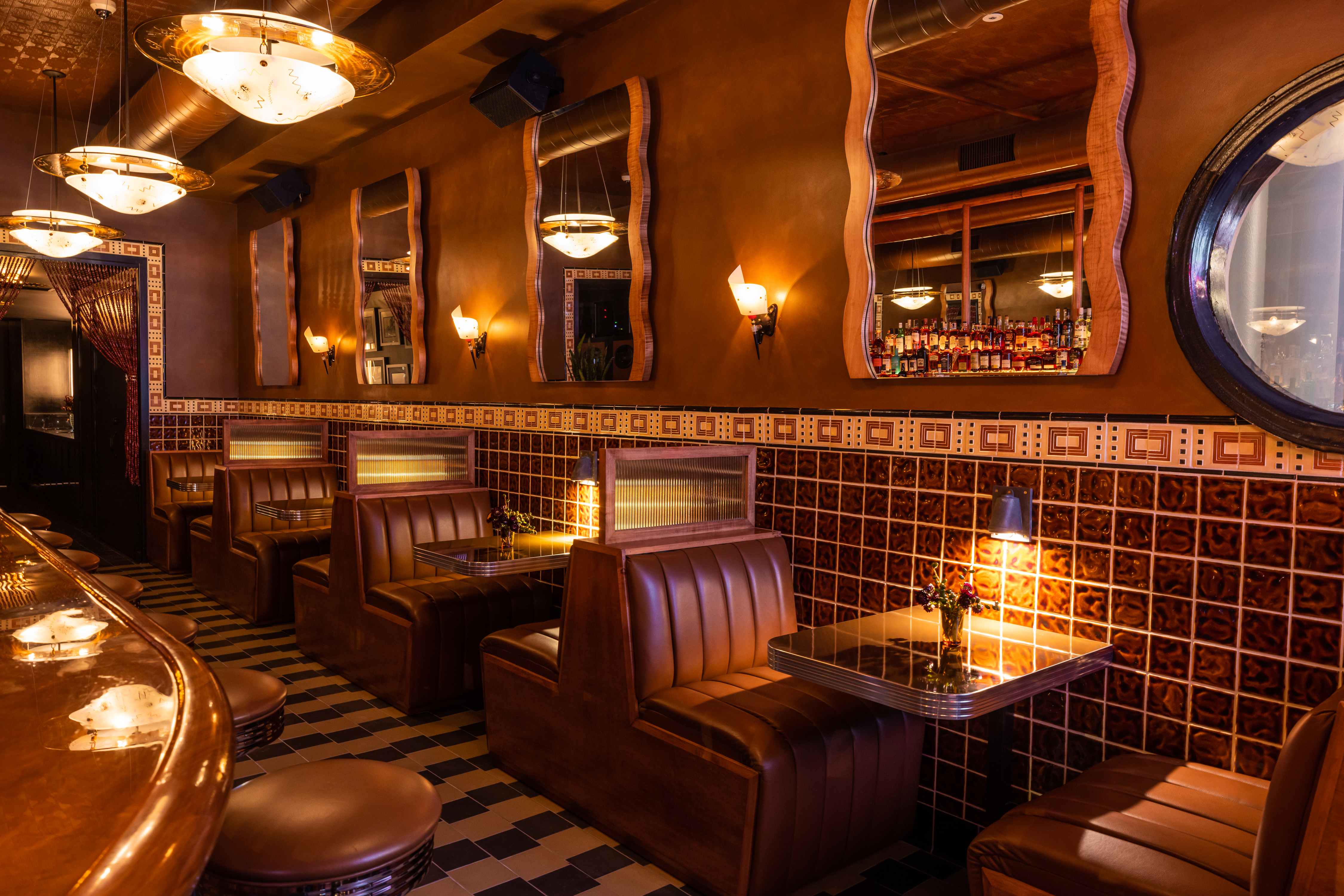 interior, booths, dim lighting, mirrors hanging on walls