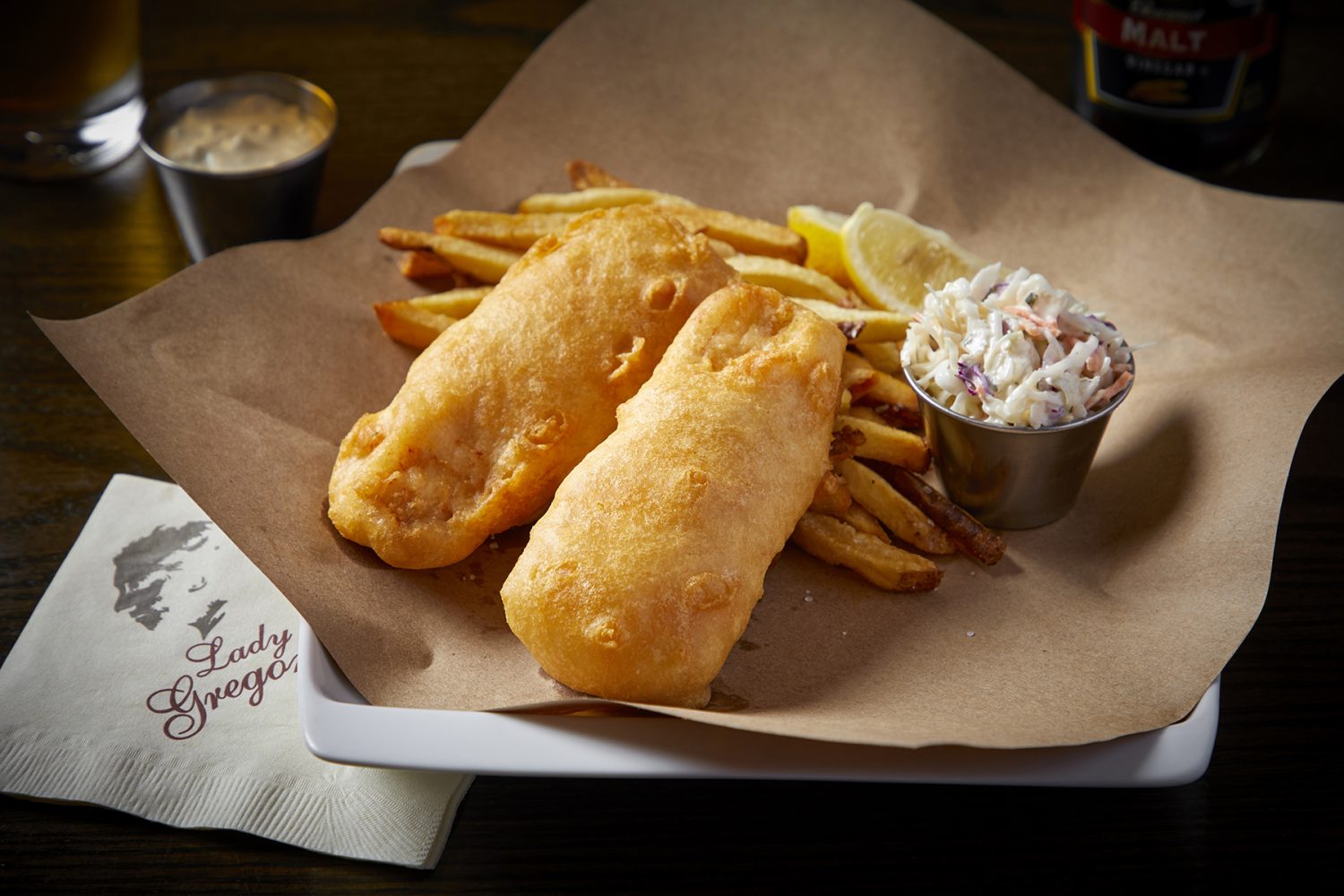 fish and chips with lemon and coleslaw on plate