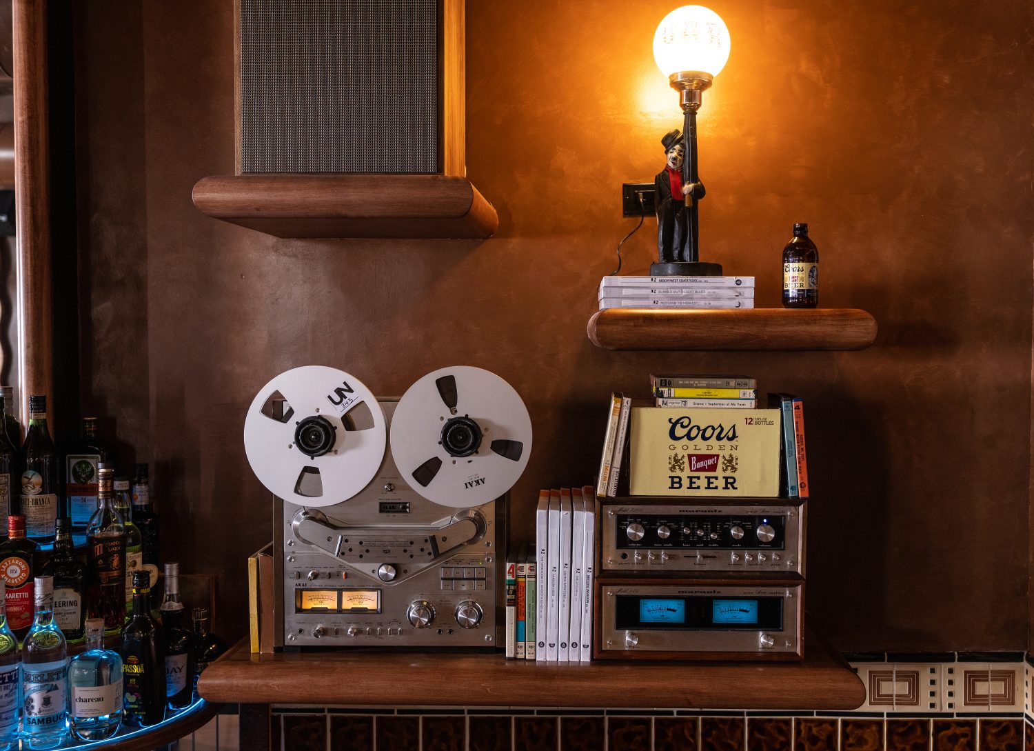 antique lamp with man on it, speakers, radios, drinks, books