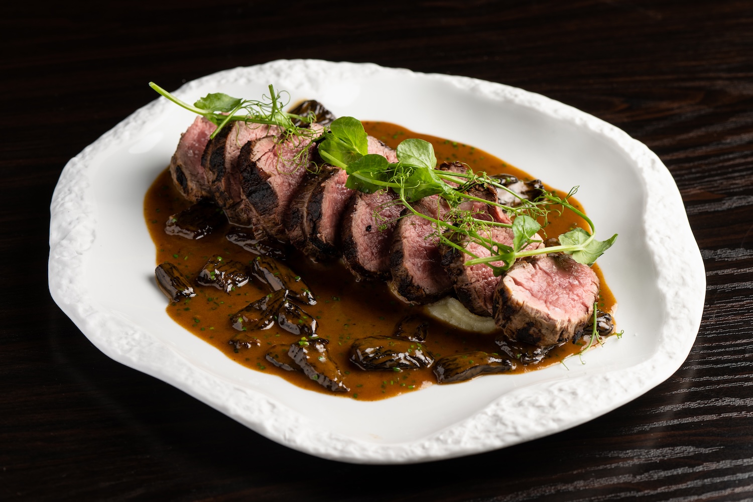 steak cut up into pieces with sauce and garnish