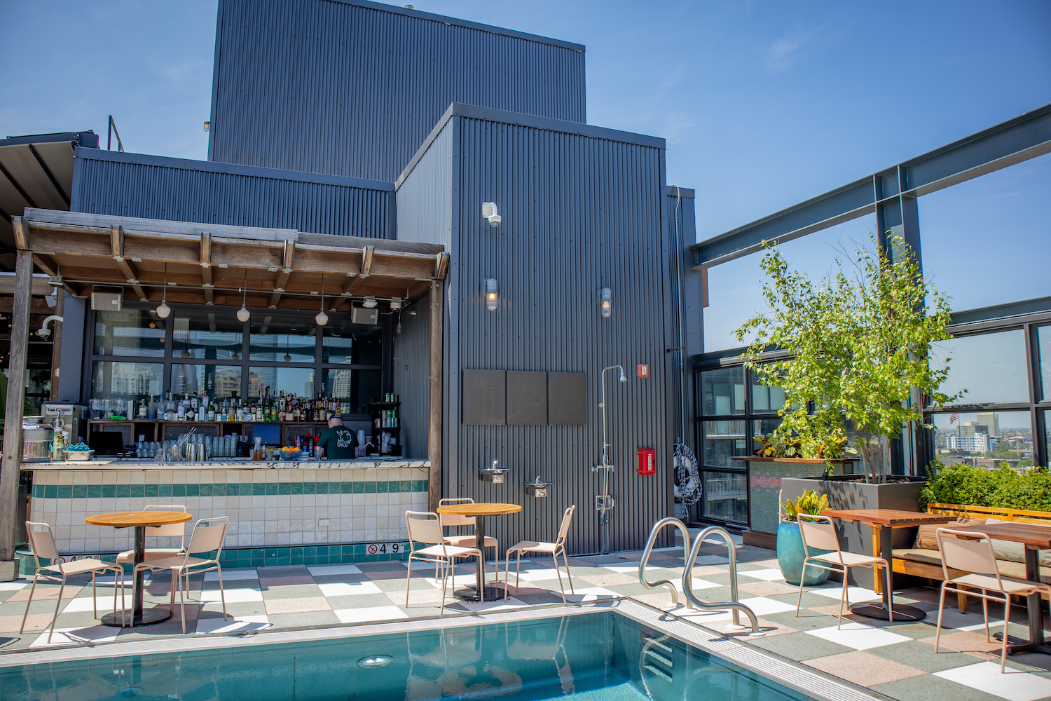 a rooftop bar in front of a swimming pool