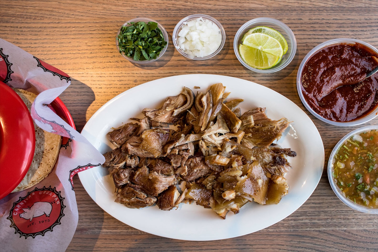 shredded meat with side of limes, onions, cilantro, and tortillas