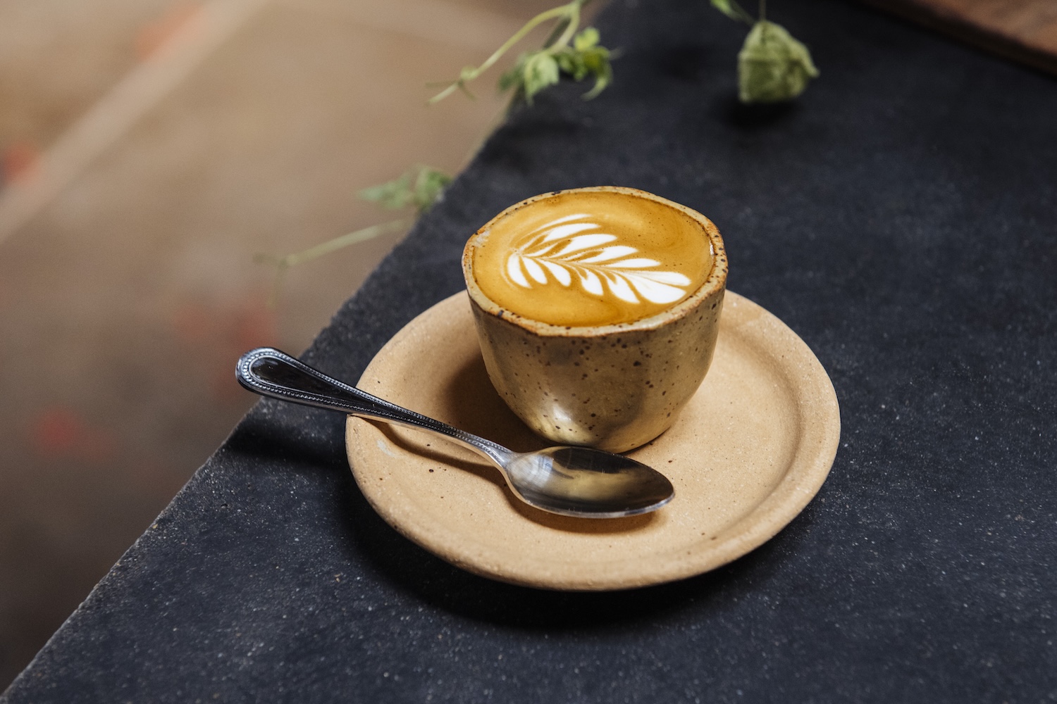 latte on a plate next to a spoon