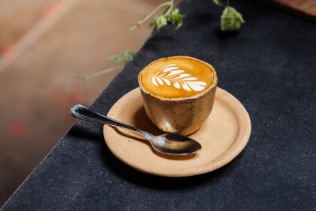 latte on a plate next to a spoon