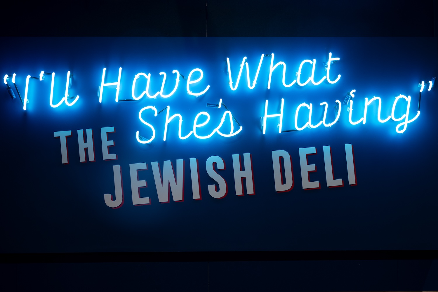 neon blue sign with cursive letters