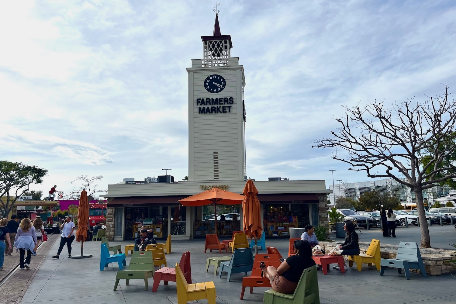 giant column building with weather vane, multi colored chairs and orange umbrellas