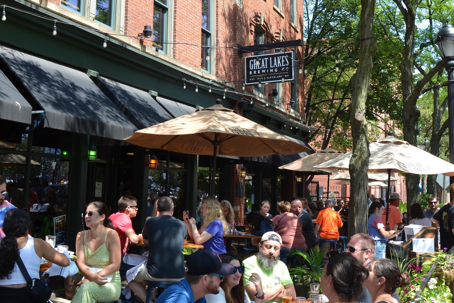 outside of great lakes brewing with people sitting on a sunny day