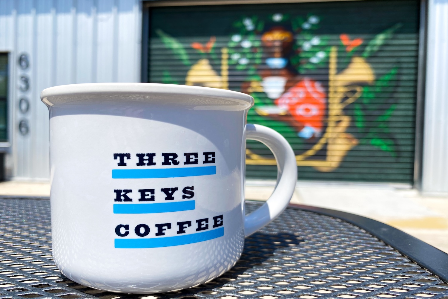 white mug with black letters and blue underlines