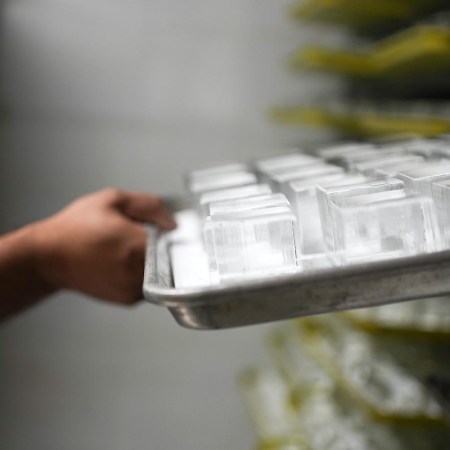 Louis Villegas, owner of Big Ice HTX, pulls out a tray of ice cubes on Monday, Aug. 28, 2023 in Houston. Big Ice HTX creates and sells luxury ice, clear ice cubes with logos or other edible items added to it for bars wanting a more unique presentation