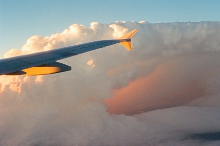 A plane wing passing through clouds.