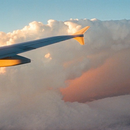 A plane wing passing through clouds.