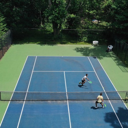 Aerial shot of two men playing tennis.