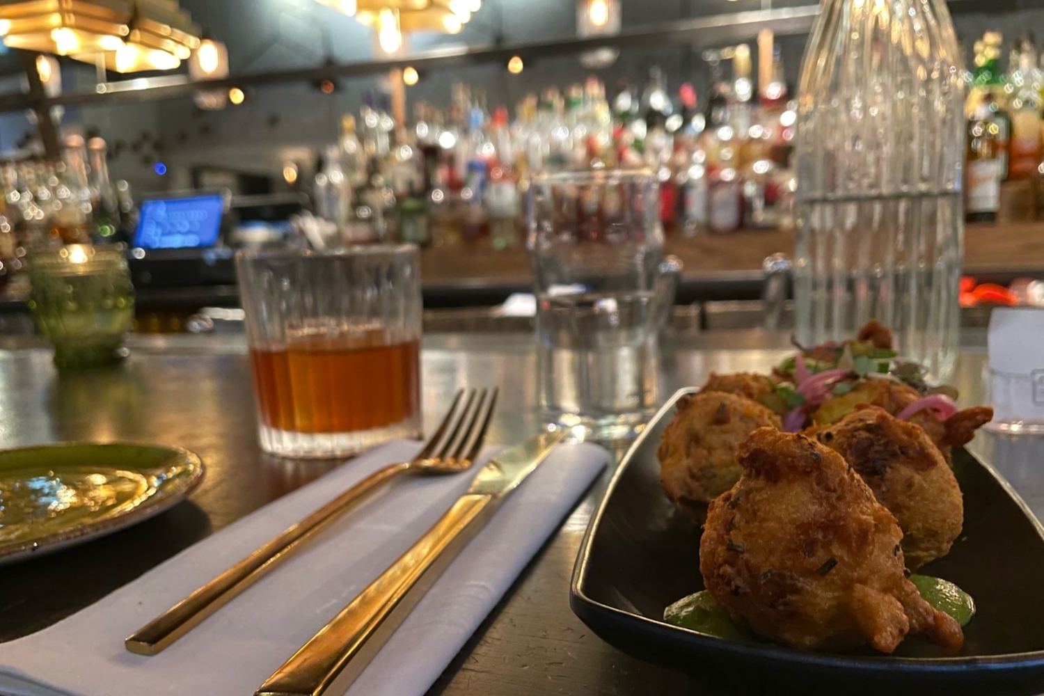 huh puppies and an old fashioned sitting on a bar with silverware