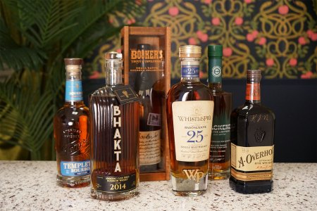 Six bottles of good whiskey coming out in May of 2024 on a bar counter