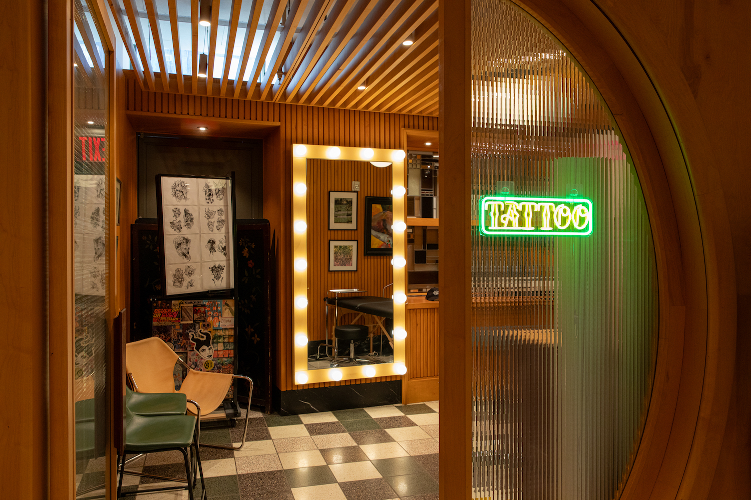 peering into a small tattoo shop with a neon sign
