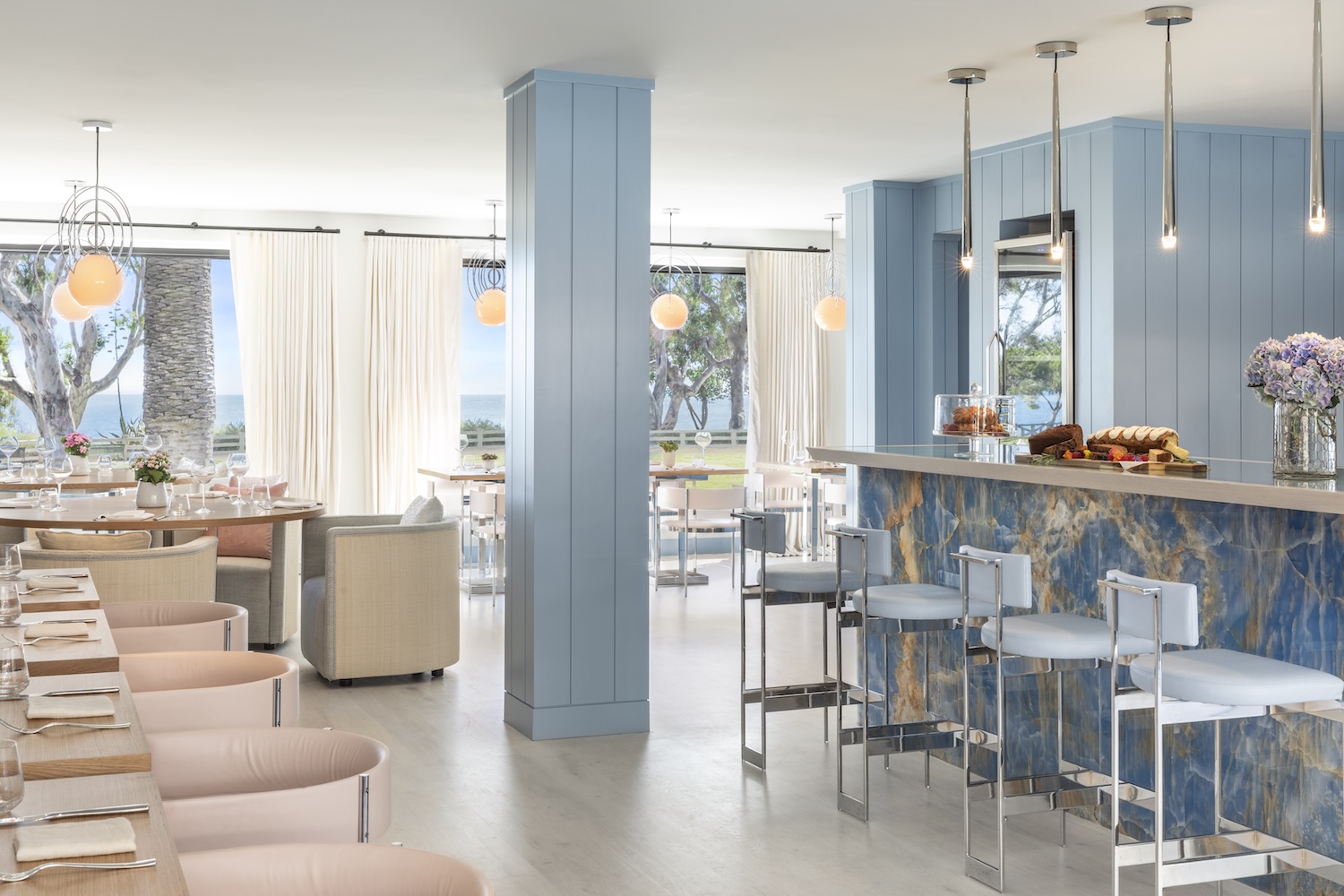 light blue columns and bar stools, white curtains, outdoors, light pink chairs