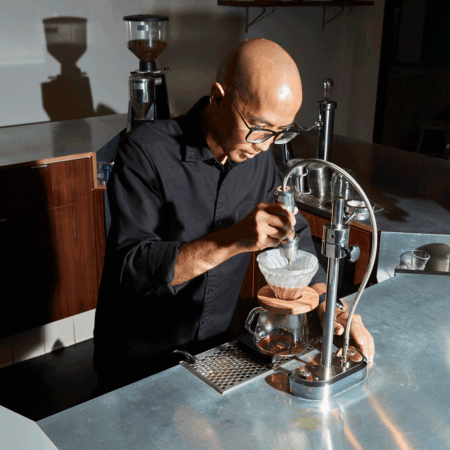 bald barista pouring coffee