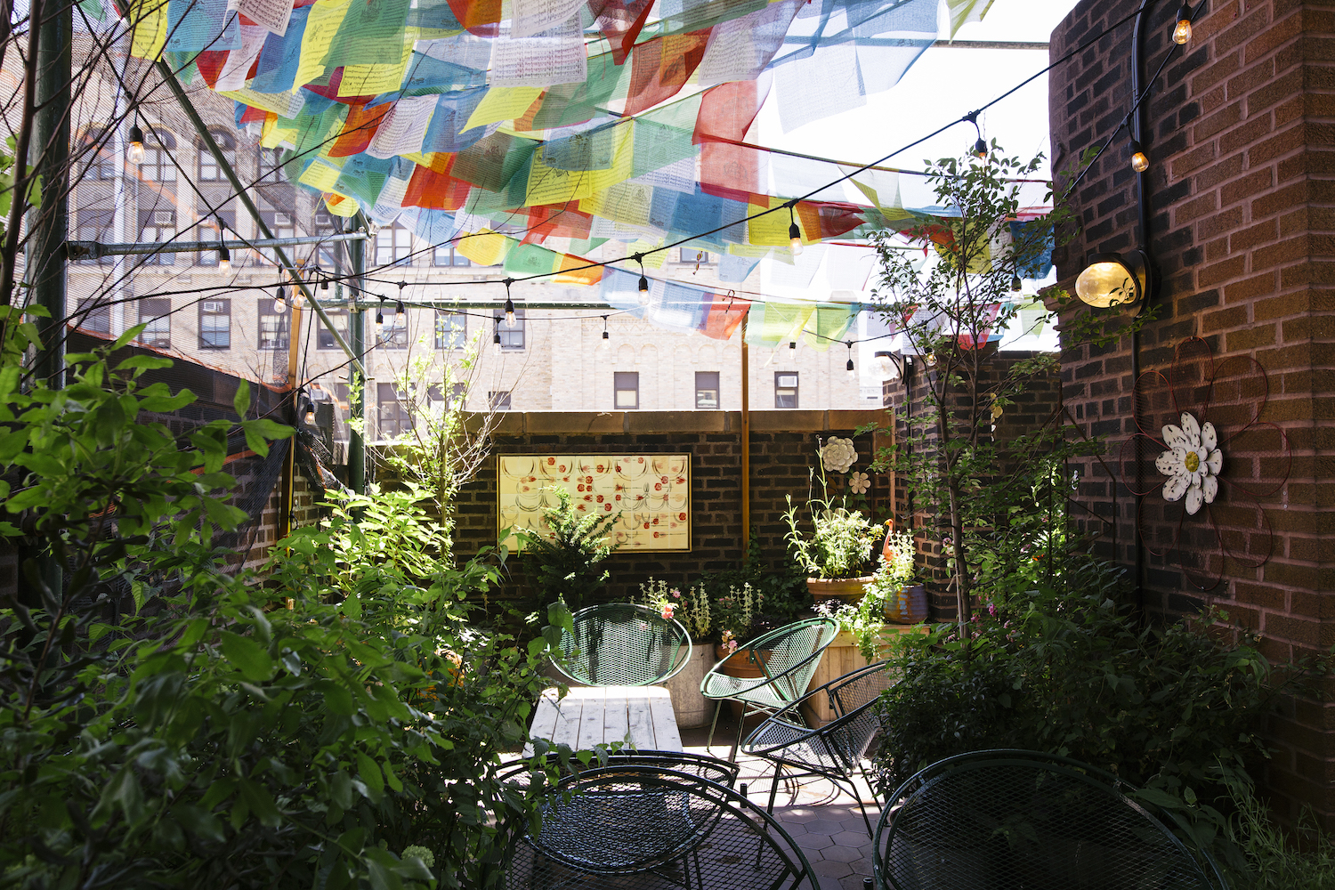 Broken Shaker seating, tucked into a rooftop green space and decorated with lines of hanging textiles