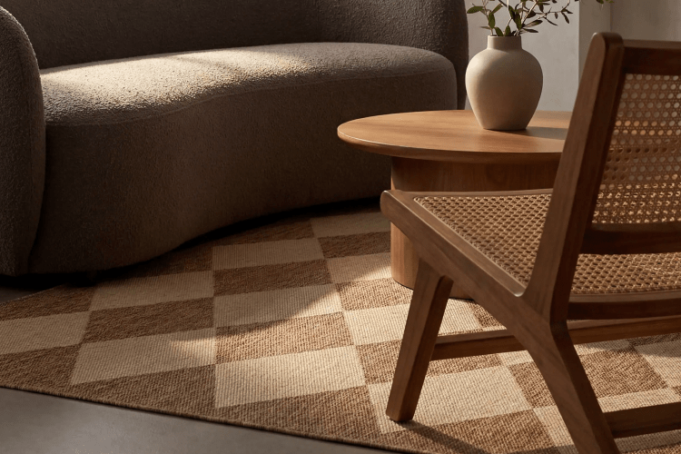 lifestyle image focused on harlequin patterned rug with a couch, chair and coffee table sitting on top