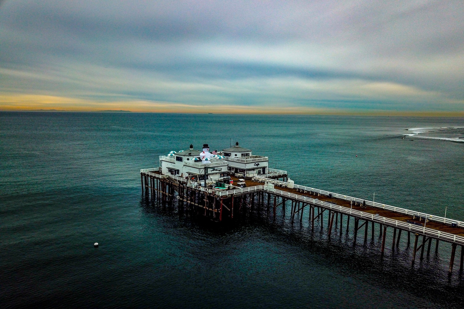 pier with restaurant, ocean surrounding, sky