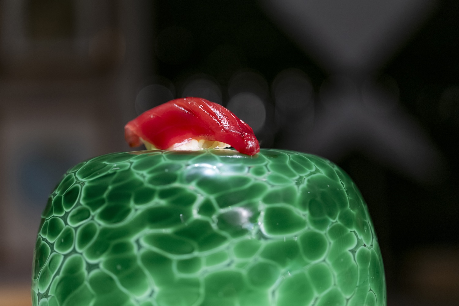 piece of tuna nigiri on top of a green object
