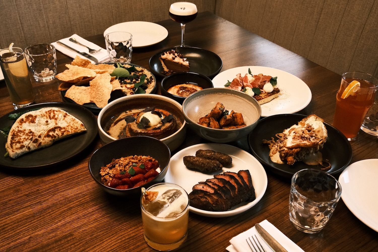 plates of food, bread, sausage, meat, dip, cake, glasses, two cocktails