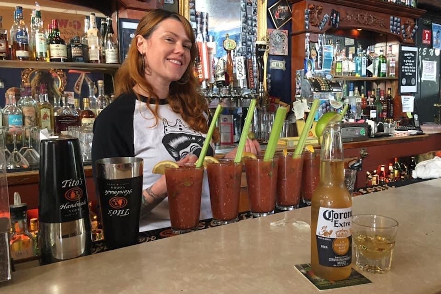 Bartender behind bar prepares several Bloody Marys