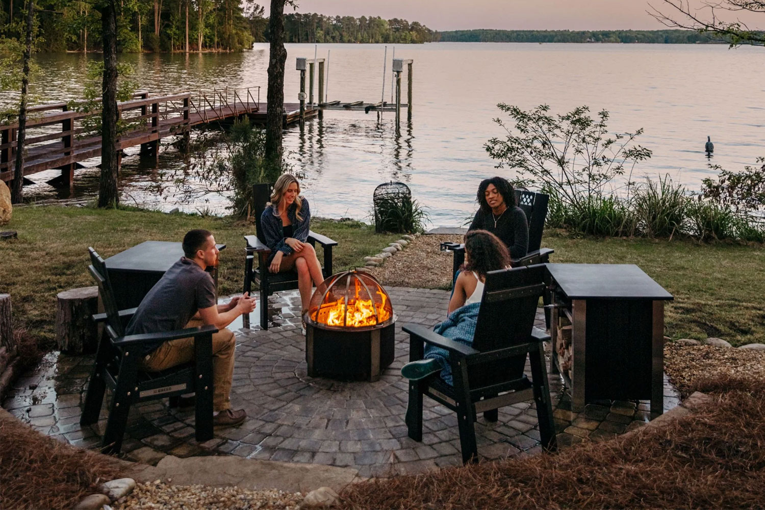 Friends sitting around a Breeo fire pit, which is designed to be smokeless