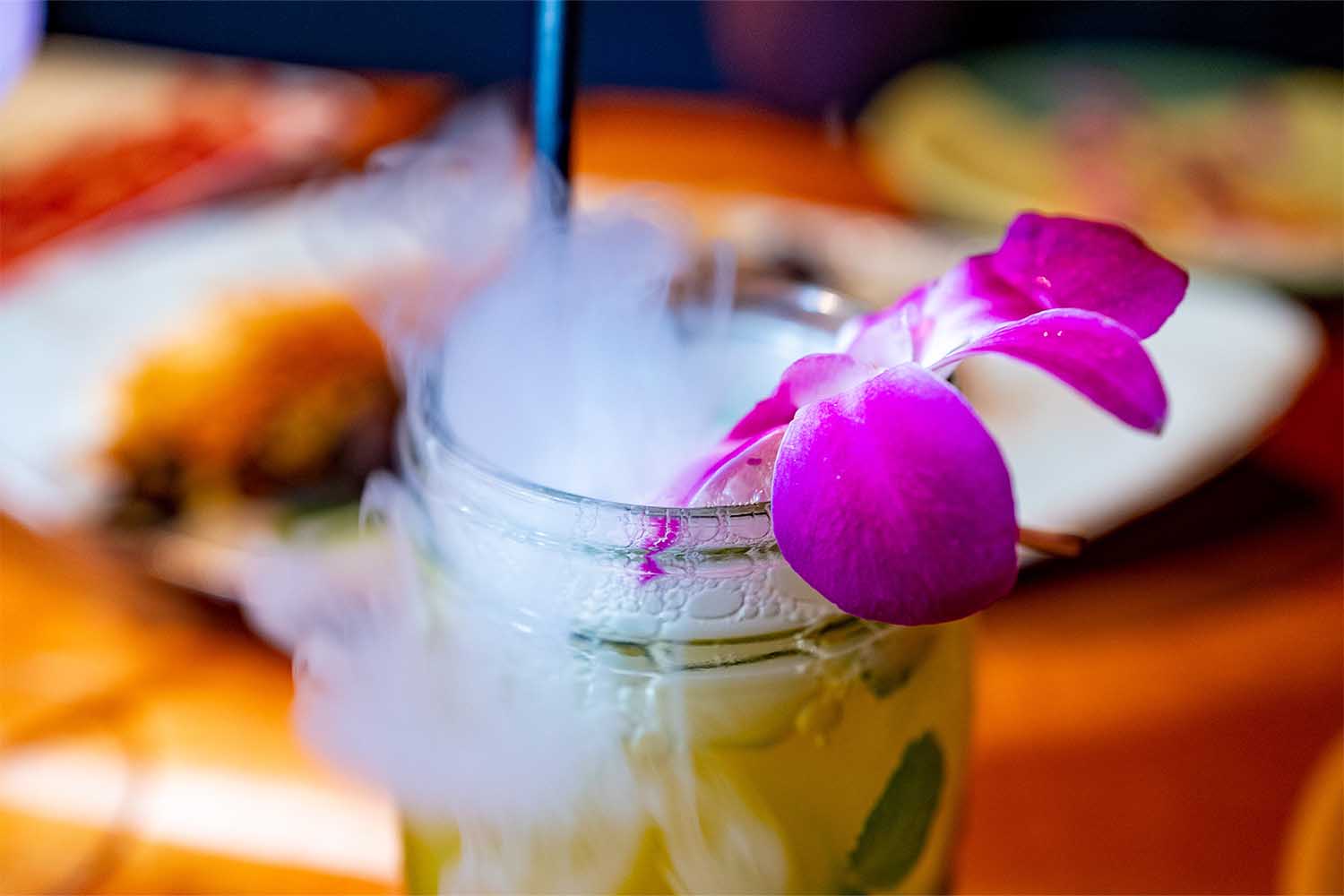 Passionfruit mojito cocktail served in a mason jar with dry ice smoke and an orchid at Teleferic Barcelona, Walnut Creek, California