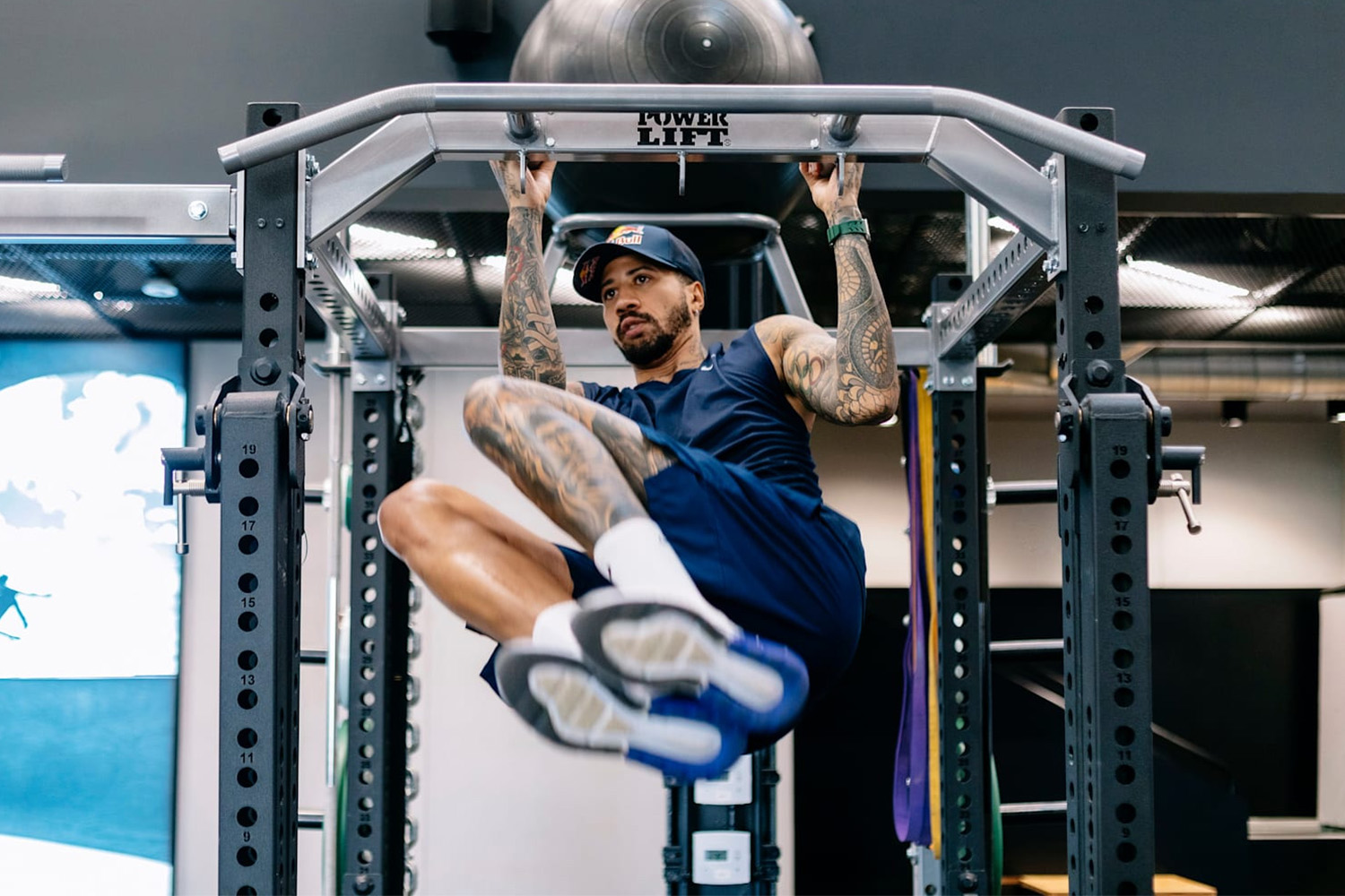 An Olympic fencer named Miles Chamley-Watson hanging from a pull-up bar.