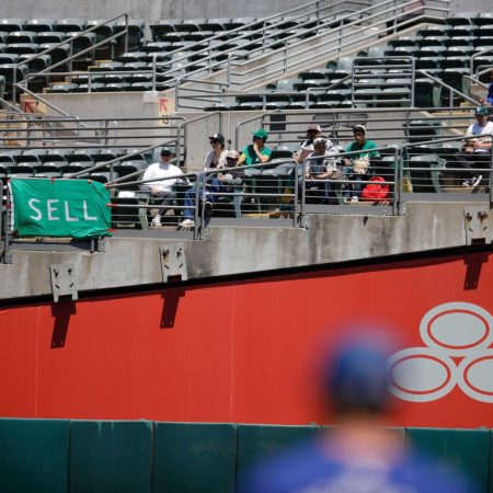 Oakland Athletics fans with signs begging ownership to sell the team.